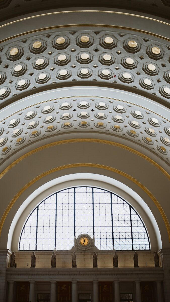 the ceiling of a large building with a clock on it